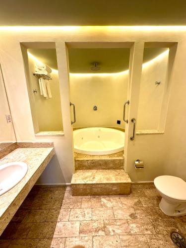 a bathroom with a tub and a toilet and a sink at San Michel Hotel in São Paulo