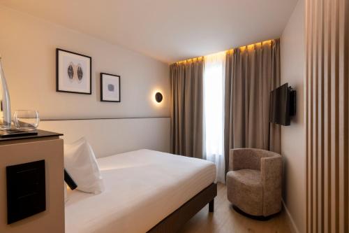 A bed or beds in a room at Hôtel Esté