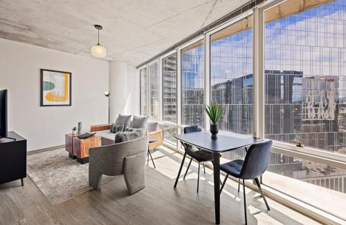 a living room with a table and chairs and a large window at Placemakr Premier SoBro in Nashville