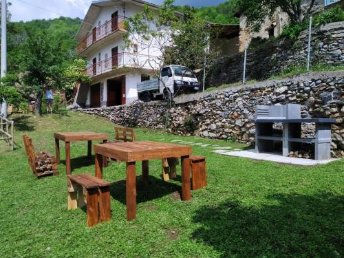 a group of wooden tables and benches in a yard at Casale Michelis in Ormea