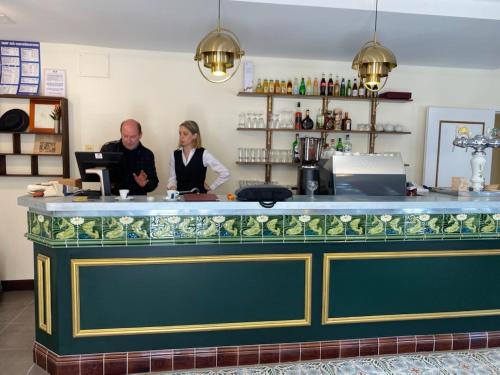 two people standing at a counter in a bar at la madeleine in Saint-Benoît-sur-Loire