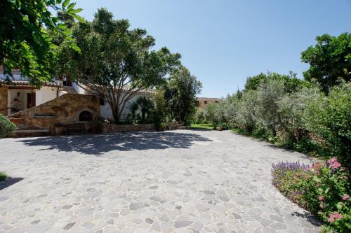 a stone driveway with trees and a building at Bilo Mare 2 in Budoni