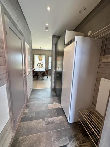 a kitchen with a white refrigerator and a hallway at Röstbergsgårdarna in Funäsdalen