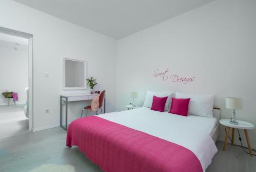 a bedroom with a large bed with a pink blanket at Apartment Alex in Labin