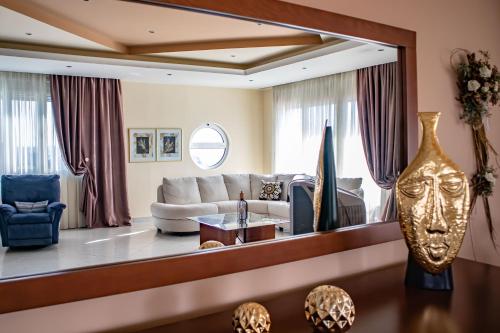un salon avec un canapé et un grand miroir dans l'établissement Mary's Luxury Residence, à Koskinou