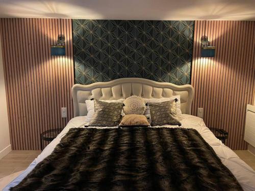 Suite d'amour et détente jacuzzi, sauna et massage في Chartrettes: غرفة نوم بسرير كبير وبجدار اسود