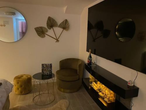 ein Wohnzimmer mit einem Kamin und einem Stuhl in der Unterkunft Suite d'amour et détente jacuzzi, sauna et massage in Chartrettes