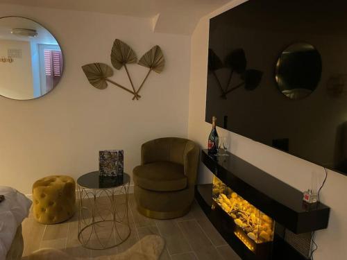 ein Wohnzimmer mit Kamin und Sessel in der Unterkunft Suite d'amour et détente jacuzzi, sauna et massage in Chartrettes