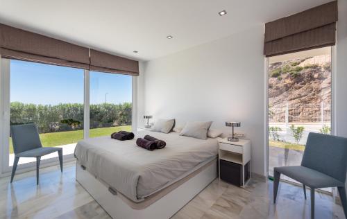 a bedroom with a large bed and two chairs at Villa Dona Julia 2410 Golf and Sea views in Casares