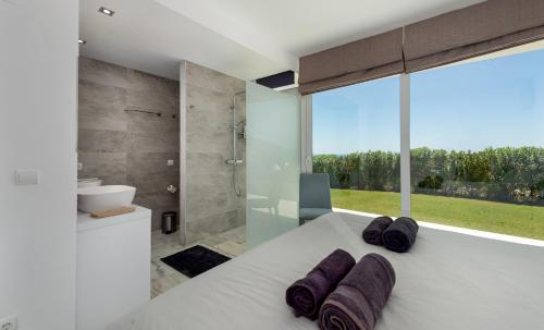 a bedroom with a large white bed and a large window at Villa Dona Julia 2410 Golf and Sea views in Casares