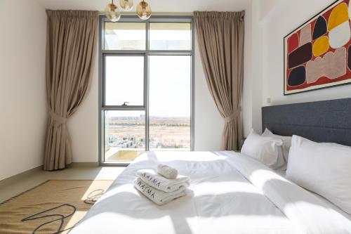 a bedroom with a white bed with a large window at Nasma Luxury Stays - Colorful Condo With Wide City Views From Balcony in Dubai