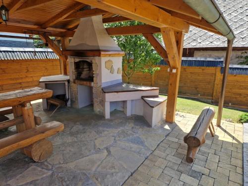 a outdoor kitchen with a wood stove in a backyard at Drevenice Osádka in Osádka
