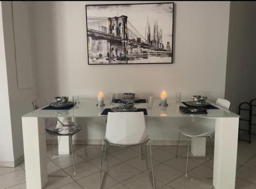 une salle à manger avec une table et des chaises blanches dans l'établissement MagnifiqueT3 Centre/Gare/Parking, à Annemasse