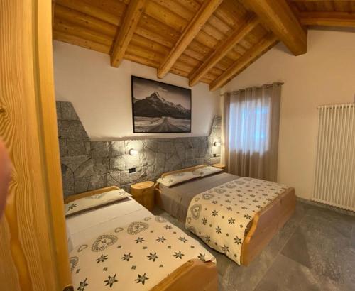 a bedroom with two beds in a room at B&B Casa il sasso in Pinzolo