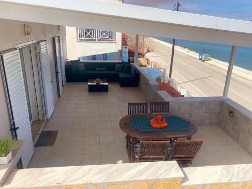 un patio con mesa, sillas y el océano en Filis mare apartment, en Xylokastro