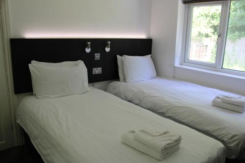 two beds sitting next to each other in a room at Cosy 3 bedroom house in quiet residential area in Manchester