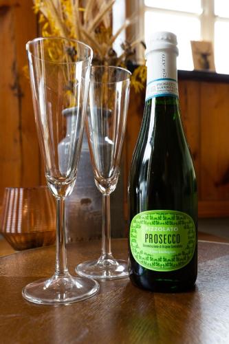 a bottle of wine and two glasses on a table at Boerenhofstede de Overhorn in Weesp