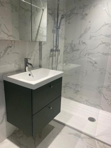 une salle de bain avec un lavabo et une douche dans l'établissement Servotel Castagniers, à Castagniers