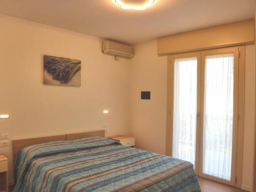リニャーノ・サッビアドーロにあるBurelloのベッドルーム1室(ベッド1台、大きな窓付)