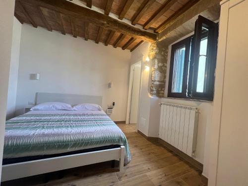 1 dormitorio con cama y ventana en Casa Aldobrandeschi Saturnia, en Saturnia