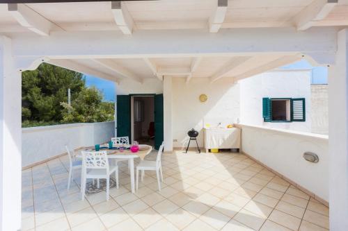 a room with a table and chairs on a balcony at La Casa di Vivì vicino al mare in Specchiolla 