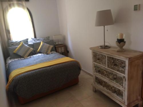 a bedroom with a bed and a lamp on a dresser at Apartamento Amarna in Benalmádena