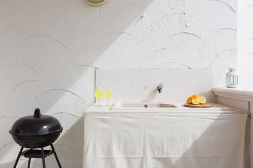 a white kitchen with a table and a grill at La Casa di Vivì vicino al mare in Specchiolla 