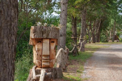 a wooden bird house sitting on a tree stump at Villino nel Bosco in Capoliveri