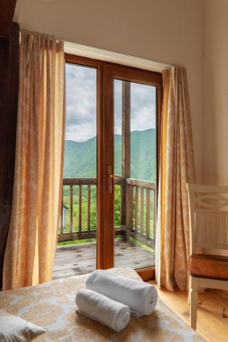 a bedroom with a large window with a view of a mountain at Snow Time Cottage in Gudauri