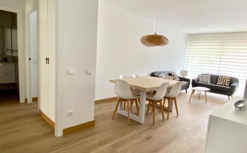 comedor y sala de estar con mesa y sillas en Apartamento con 3 habitaciones, terraza y jardin comunitario con piscina en Sant Antoni de Calonge en Sant Antoni de Calonge