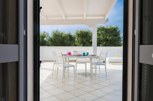 a dining room with a table and chairs on a patio at La Casa di Vivì vicino al mare in Specchiolla 