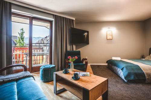 ein Hotelzimmer mit einem Bett und einem Sofa in der Unterkunft VisitZakopane - Szafran Apartment in Zakopane