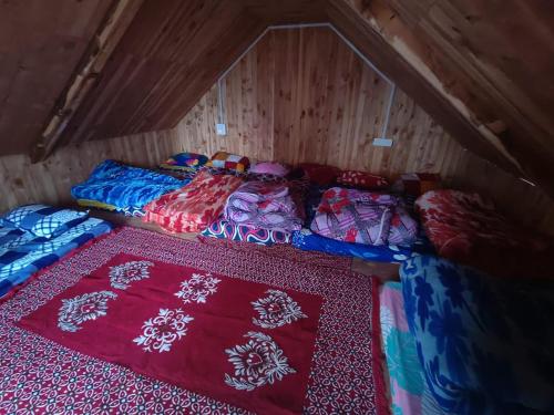 a couple of beds in a small room at Deep In Woods in Jibhi