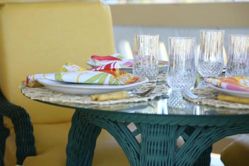 una mesa verde con platos y vasos. en Jannetta's @Whimhill Bed & Breakfast en Negril