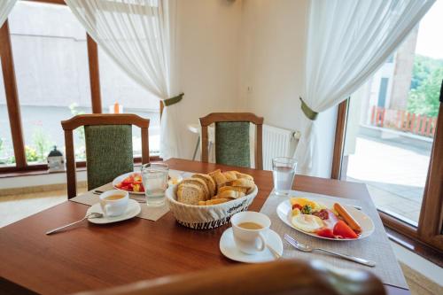 a table with a basket of bread and a bowl of fruit at Pensiunea Comfort in Sovata