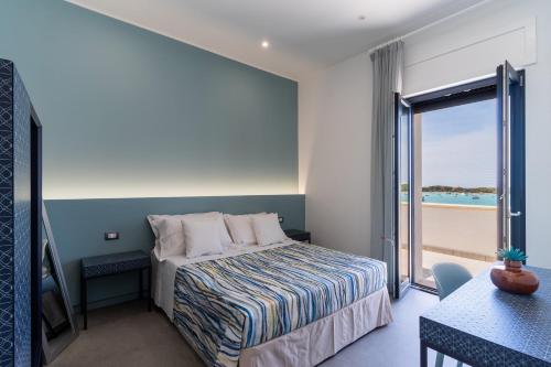 um quarto com uma cama e vista para o oceano em Residence Medusa by BarbarHouse em Porto Cesareo