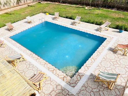 a large swimming pool with chairs and a table at Unique Villa Castle With Pool in Essaouira