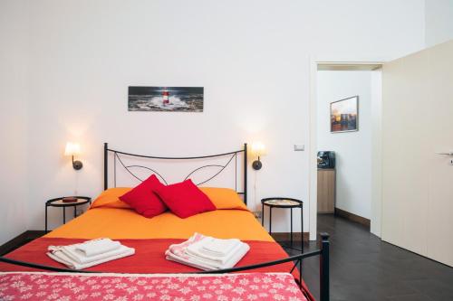 a bedroom with an orange bed with red pillows at Antico Borgo in Catania