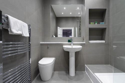 a bathroom with a sink and a toilet and a mirror at Luxury Apartment/Flat Edinburgh City Centre in Edinburgh