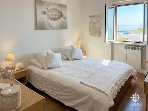 a bedroom with a large bed with a window at Infinito - Attico sul mare in Vieste