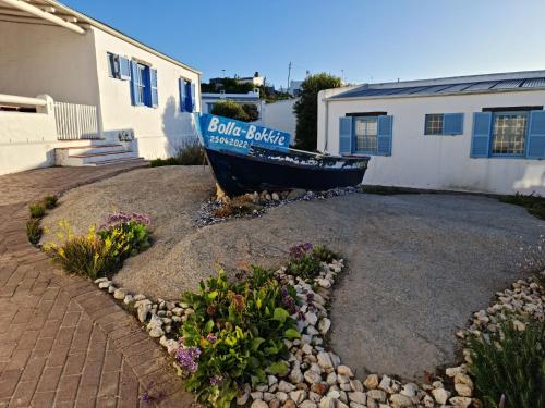 a boat sitting in a yard next to a house at Flamink Beach View Cottage in Paternoster in Paternoster