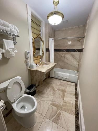 a bathroom with a toilet and a sink and a tub at The Union Hotel in Everett