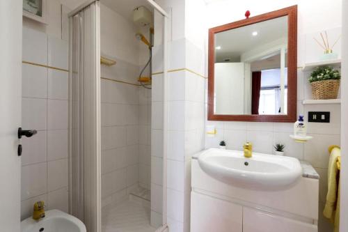 een witte badkamer met een wastafel en een spiegel bij Sikelia Apartment Taormina in Taormina