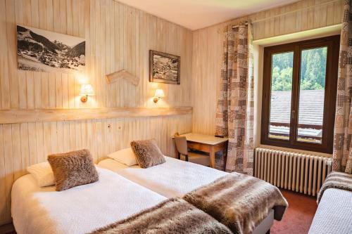 a hotel room with two beds and a window at Hôtel Viallet in Arêches-Beaufort