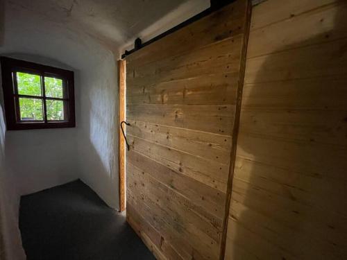 a wooden wall in a room with a window at UNESCO 14 century in Český Krumlov