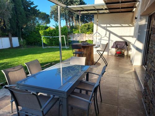 a glass table and chairs on a patio at Villa proche mer, montagne et Espagne in Le Soler