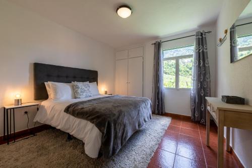 Un dormitorio con una cama grande y una ventana en Pereira Place - Cottage, en São Vicente