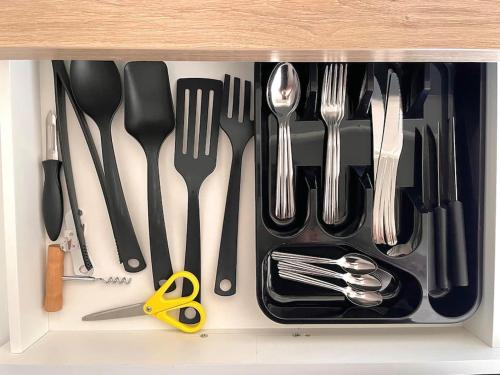 un tiroir plein d'ustensiles dans un tiroir dans l'établissement Studio avec vue panoramique mer hippodrome, à Cagnes-sur-Mer