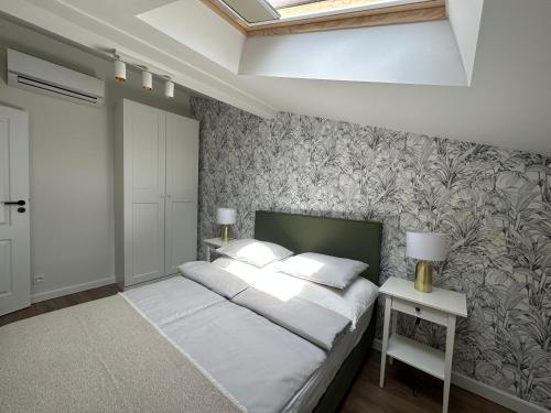 1 dormitorio con 1 cama y un mural en la pared en Abrahama Green House, en Władysławowo