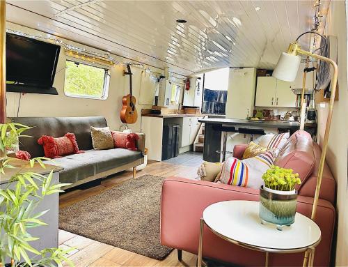 sala de estar con sofá y mesa en Boutique Boat Stays Contemporary Barge en Bath